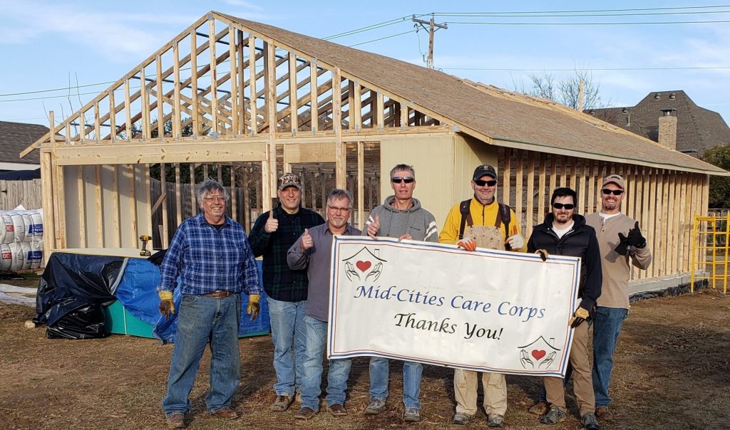 Volunteers standing in front of nearly finished storage shed for MCCC